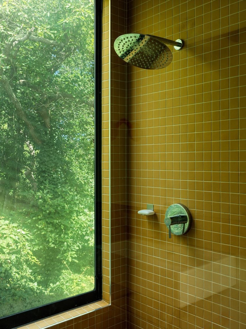 Shower lined with bright yellow square tiles
