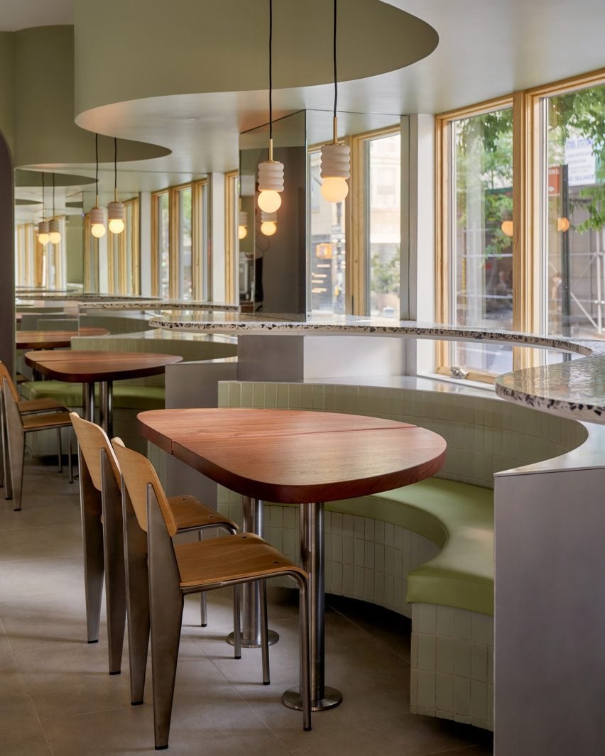 A dropped ceiling follows the curved line of banquettes and tables below