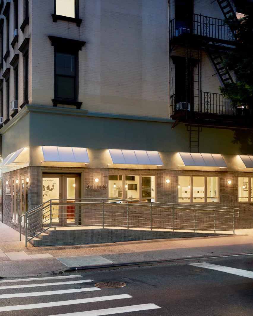 Restaurant exterior with reeded concrete tiles, chrome sconces and white awnings